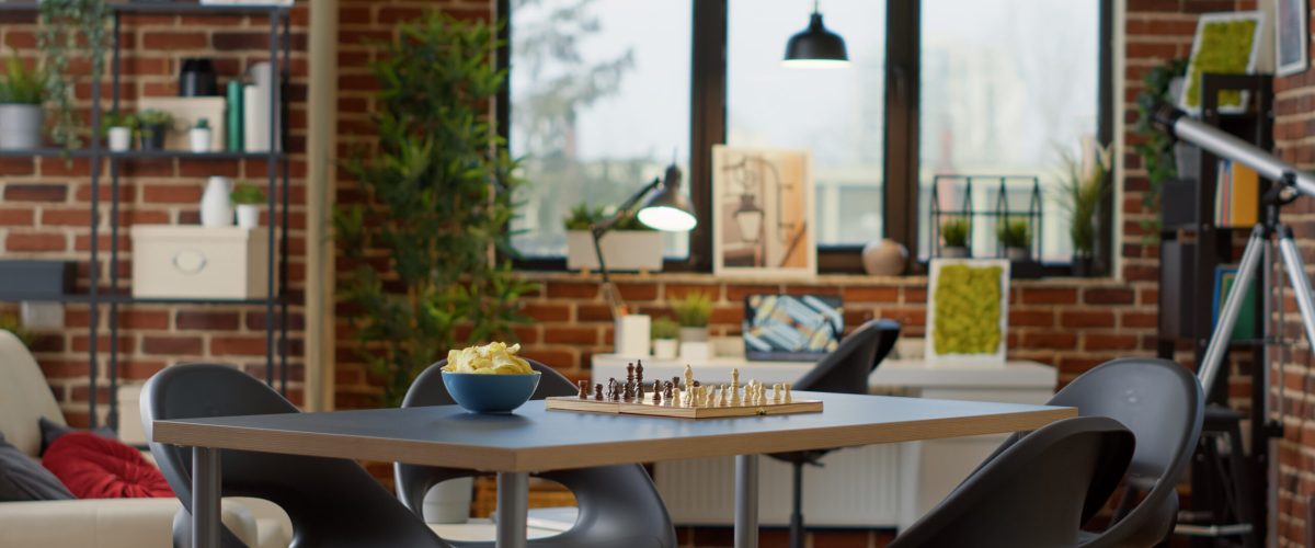 Empty living room decorated for fun gathering with friends, having alcoholic drinks and snacks. Nobody in apartment with modern board games and chess to enjoy home meeting for entertainment.
